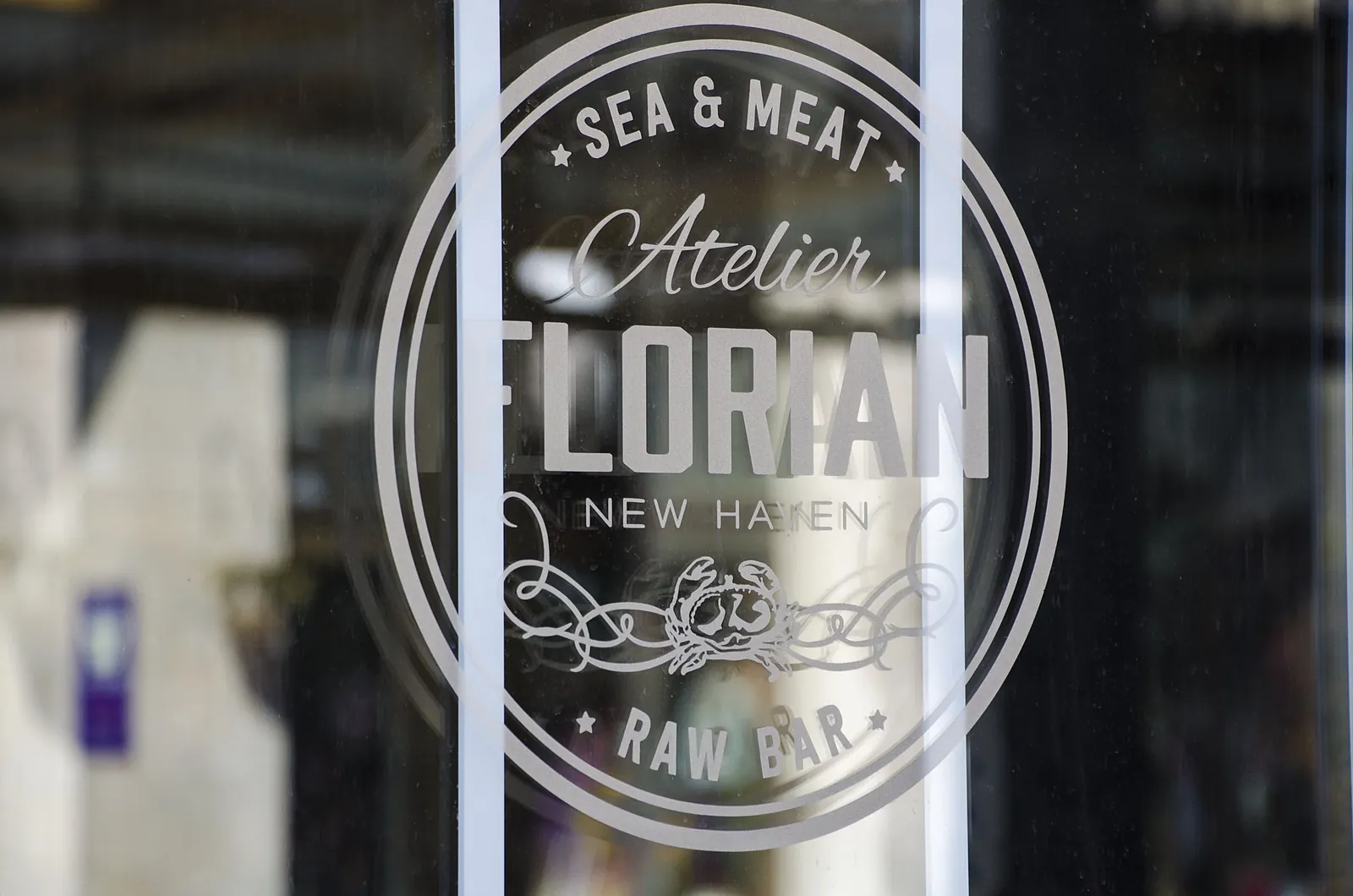 Atelier Florian's sea and meat raw bar emblem etched on the restaurant's glass door
