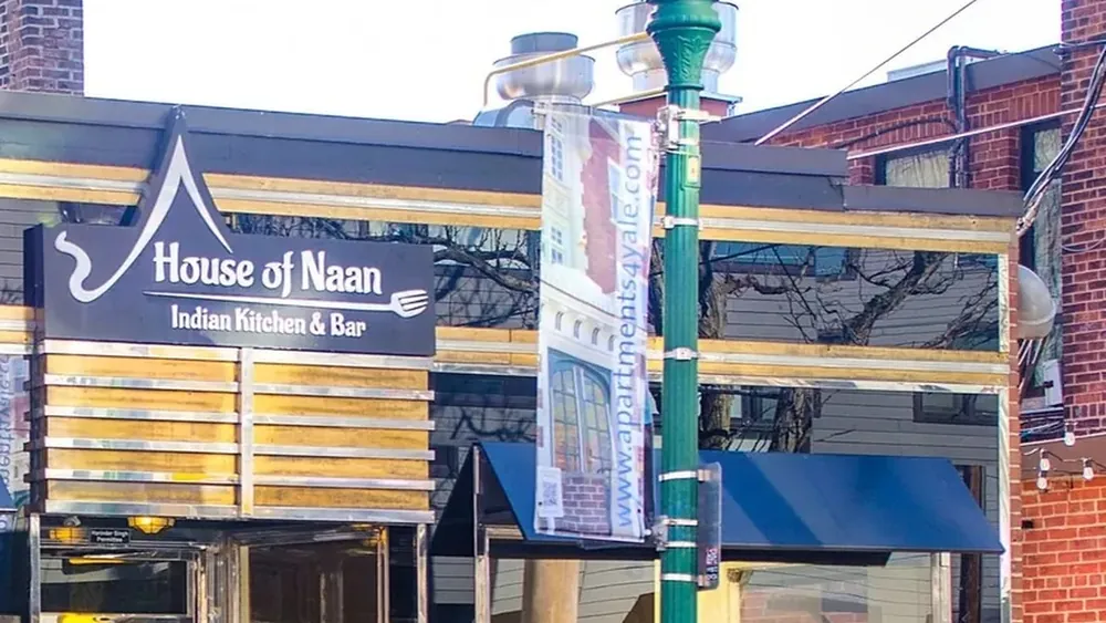 The House of Naan storefront on Howe Street with its Indian Kitchen and Bar sign, glass front and a green district lamppost on the corner.