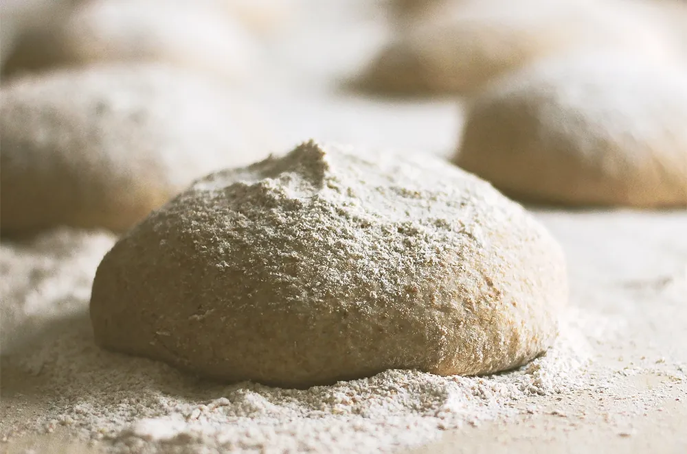 A ball of pizza dough dusted with flour at Ricotta Pizza and Bakery