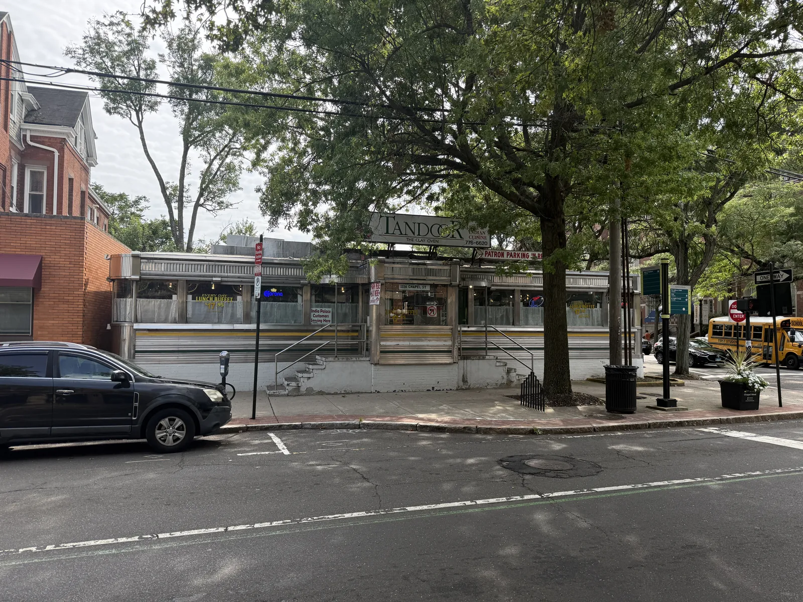 Tandoor at 1226 Chapel Street, a stainless steel diner car banded in green and yellow beneath mature street trees, its roof sign reading Tandoor Indian Cuisine, The Clay Oven