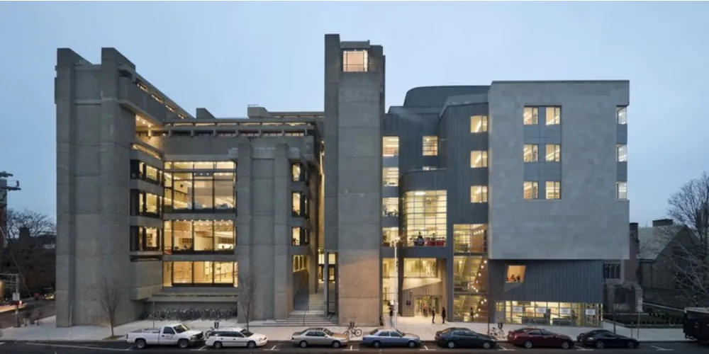 Rudolph Hall at dusk, the concrete tower of the Yale School of Architecture, its studio floors lit from within