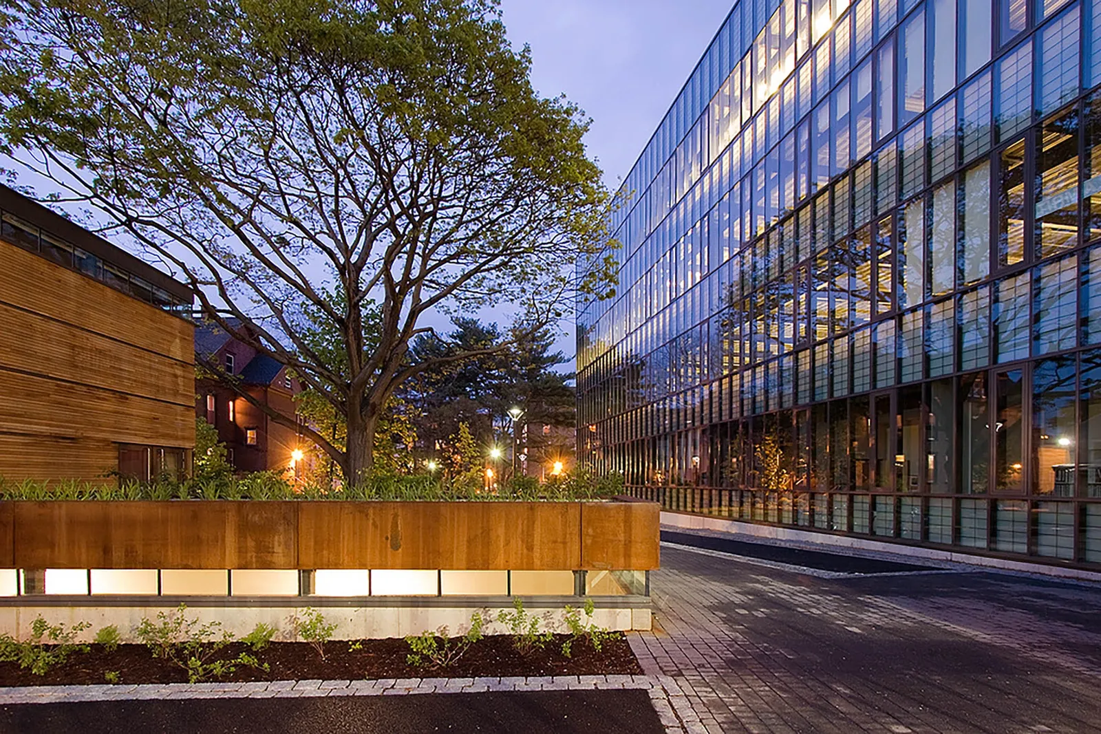 The Yale sculpture building at dusk, a long glass facade reflecting the trees across the street